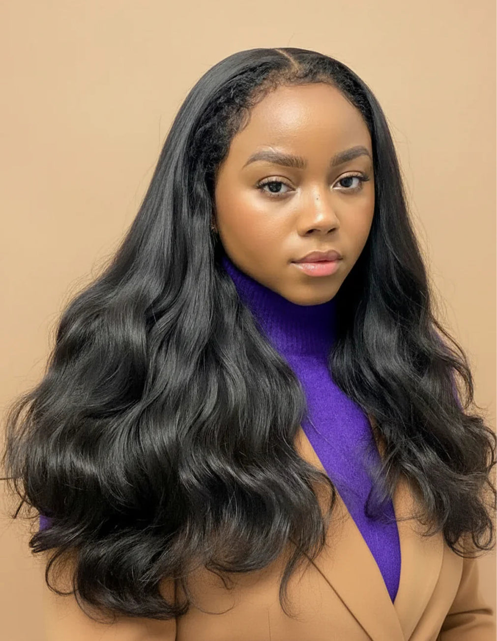Model wearing Natural Black Raw Wavy Wig, 13x6 HD Lace frontal, 18-24 inch, effortless natural look, glueless comfortable fit, flowing bouncy waves.