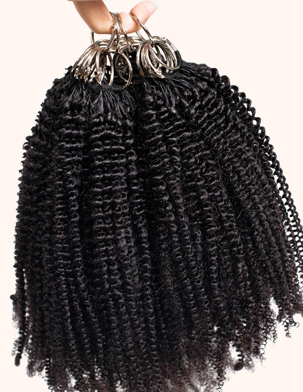 Bundles of curly hair extensions held together with a white background